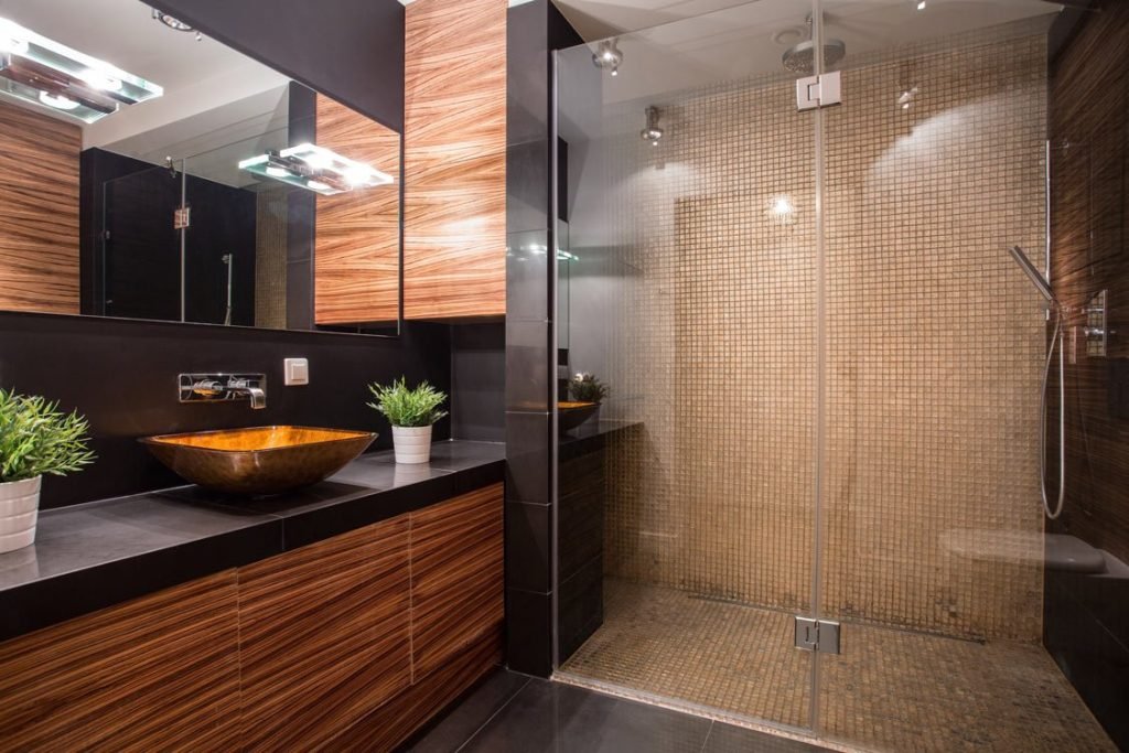 Modern bathroom with a glass walk-in shower and mosaic tile walls