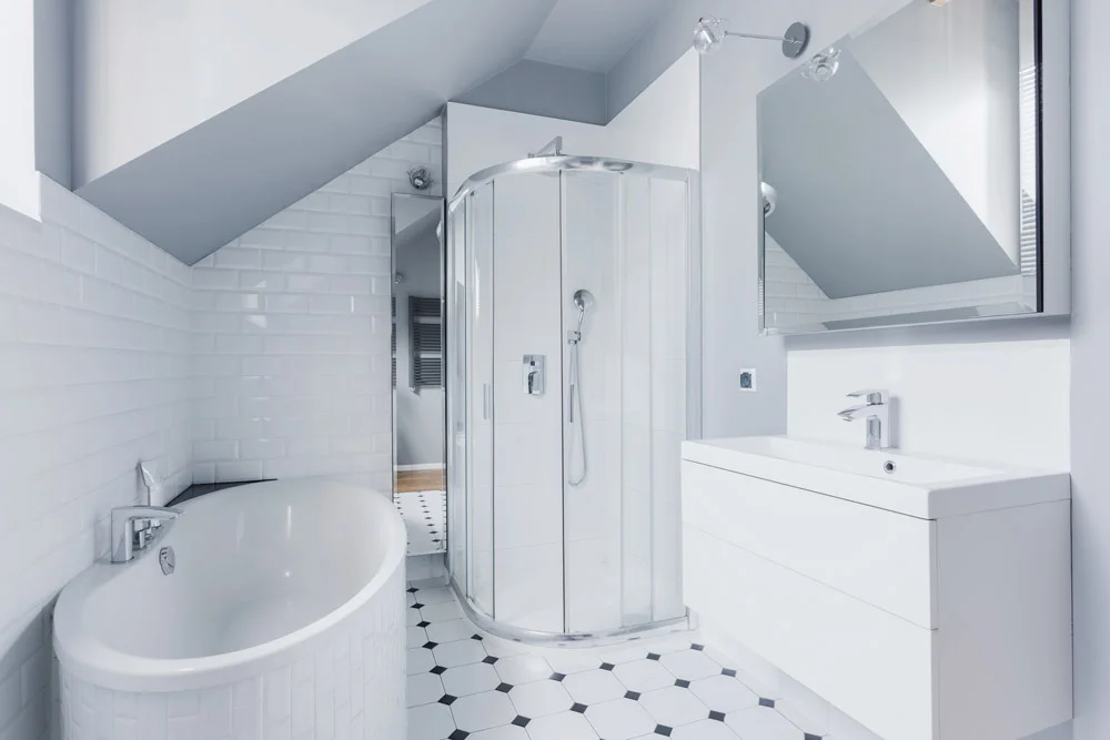 Bright white bathroom with clean subway wall tile, restored grout lines and a black and white tile floor